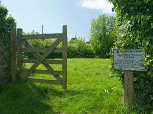a gate in a field with a sign in the grass at No 1 The Hinges in Newquay