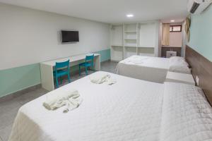 a room with two beds and two blue chairs at Pousada Praia de Porto in Porto De Galinhas +80 photos