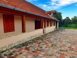 un edificio con techo rojo y patio de ladrillo en Hegyalja Vendégház en Tolcsva