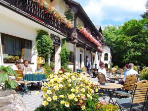 eine Gruppe von Personen, die außerhalb eines Gebäudes an Tischen sitzen in der Unterkunft Landhaus-Pension Zum Waffenschmied in Brand