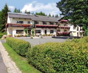 a large white building with flowers on it at Landhaus-Pension Zum Waffenschmied in Brand