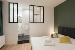 una camera da letto con un letto e due asciugamani di Le Confident - Grand T2 au coeur de Lyon a Lione