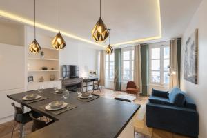 a living room with a table and a blue couch at Le Confident - Grand T2 au coeur de Lyon in Lyon