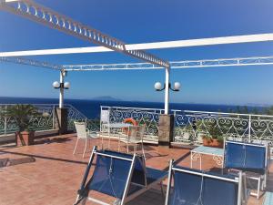 a patio with chairs and a table on a balcony at Hotel Dania in Sorrento