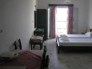 a bedroom with two beds and a table and chairs at Knossos in Panormos Rethymno