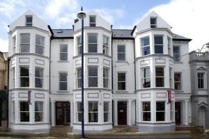 a large white building with two windows at Adelphi Portrush in Portrush