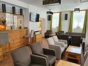 a waiting room with couches and chairs and a tv at Pension Janský Potok I. in Janske Lazne
