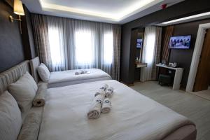 a hotel room with two beds with slippers on them at KAR BEYAZ HOTEL BURSA in Bursa