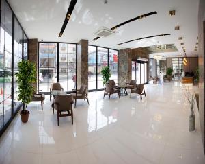 un gran vestíbulo con mesas, sillas y ventanas en KAR BEYAZ HOTEL BURSA, en Bursa