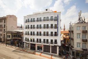 a white building on a city street with buildings at KAR BEYAZ HOTEL BURSA in Bursa