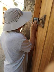 a man in a hat unlocking a door with a cell phone at Artisan´s House in Agüimes