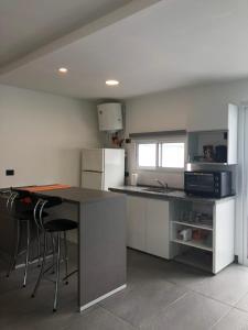 a kitchen with a counter and some stools in it at Departamento en Villa Allende in Villa Allende