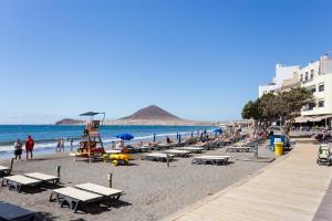 uma praia com um monte de pessoas e o oceano em 122 SEA PEARL Holiday Home by Sunkeyrents em El Médano