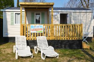 洛特佐拉伊的住宿－Happy Camp Mobile Homes in Camping Iscrixedda，两把椅子坐在一个小房子前面