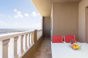 uma varanda com uma mesa e cadeiras e uma taça de fruta em 122 SEA PEARL Holiday Home by Sunkeyrents em El Médano