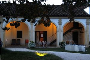 een huis met een tafel en stoelen ervoor bij Villa Pastori in Mira