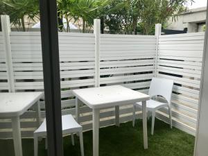 two white tables and chairs next to a fence at Ruby in La Rochelle