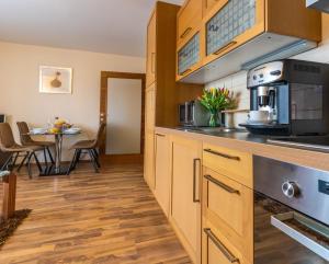 a kitchen with wooden cabinets and a table with chairs at Central Apartment in Donovaly