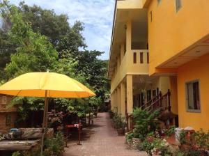 沙美島的住宿－MossMan House，坐在大楼外的黄伞