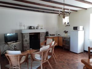 cocina con mesa, sillas y chimenea en Gite Coriosolites, en Quemper-Guézennec