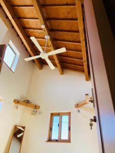 a ceiling fan in a room with wooden ceilings at 毎日が休日 guest house in Aizuwakamatsu