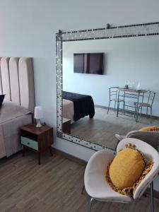 1 dormitorio con espejo, cama y mesa en Departamento costado mall plaza, Balmaceda Antofagasta en Antofagasta