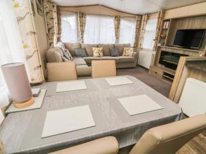 a living room with a table and a couch at 12A Borwick Lakes in Carnforth