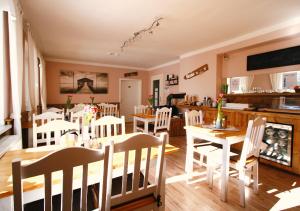 ein Esszimmer mit weißen Stühlen und einem Tisch in der Unterkunft Haus am Bach - gemütliche Frühstückspension in Allershausen