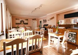 a dining room with white chairs and a table at Haus am Bach - gemütliche Frühstückspension in Allershausen