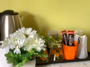 una mesa con flores y cepillos de dientes y una taza de pasta de dientes en MossMan House en Ko Samed