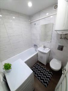 y baño blanco con lavabo, aseo y bañera. en Апартаменты Marin в самом центре en Járkov