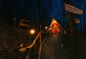 una cabaña de madera en el bosque por la noche en Etno Village Dolina Sreće, en Vitez