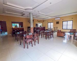 uma sala de jantar com mesas e cadeiras num restaurante em THE ESCAPE LODGE em Lusaka