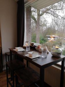 une table en face d'une fenêtre avec vue sur un arbre dans l'établissement Benvenuto, à La Haye