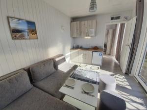 a living room with a couch and a table at Domki PrzystańTu in Jastarnia