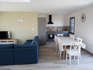 a living room with a blue couch and a table and chairs at au coeur des caps in Audinghen