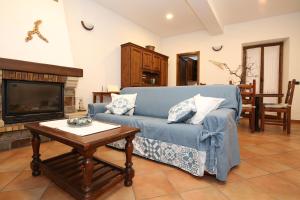 a living room with a blue couch and a coffee table at Mella Bellagio Al Porto - Apartment with terraces near the Lake - Parking in Bellagio