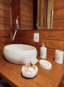 a bathroom sink sitting on a wooden counter top at Chalé da Conquista in Visconde De Maua +35 photos