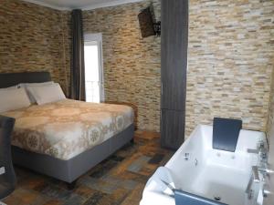um quarto com uma cama e uma banheira ao lado de um lavatório em Luxury Living Apartments and Spa em Tessalônica