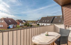 - une table et des chaises en bois sur un balcon avec des maisons dans l'établissement Amazing Apartment In Friedrichskoog With Kitchen, à Friedrichskoog-Spitz