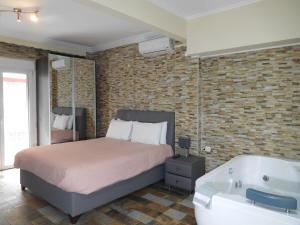 a bedroom with a bed and a bath tub at Luxury Living Apartments and Spa in Thessaloniki
