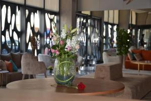 een vaas gevuld met bloemen zittend op een tafel bij Flower Town Hotel & Spa in Rabat