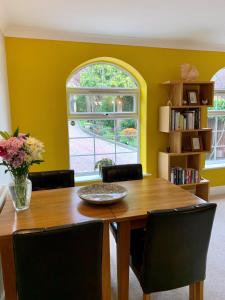a dining room with a wooden table and chairs at Homelands Apartment in Cheltenham