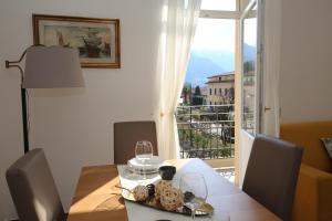 a dining room table with a view of a balcony at Mella Bellagio Rosa Dei Venti - Elegante appartamento nel cuore di Bellagio con parcheggio privato in Bellagio