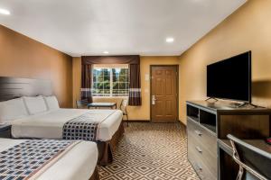 a hotel room with two beds and a flat screen tv at Americas Best Value Inn - Ukiah in Ukiah