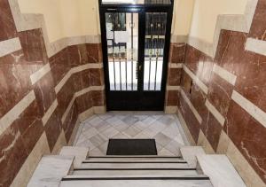 un corridoio con porta nera e scale in un edificio di Pension Salamanca a Salamanca Altre 156 foto