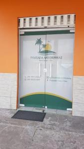 a large glass door with a palm tree on it at Pousada Andorinhas in Santo Amaro