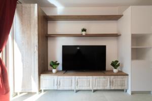 a living room with a flat screen tv on a entertainment center at Stars & Mountain Apartment in Buşteni