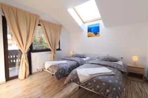 two twin beds in a room with a window at Stars & Mountain Apartment in Buşteni