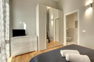 1 dormitorio con 1 cama, TV y espejo en Sleep Tight Florence (Rooms), en Florencia